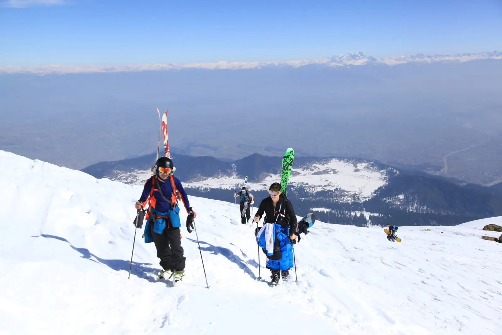 Skiers and snowboarders hiking a Gulmarg ridge for backcountry access