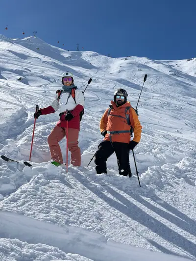 Two guided skiers posing in deep powder near Apharwat