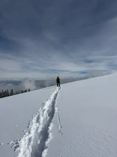 Lone climber ascending a steep powder slope